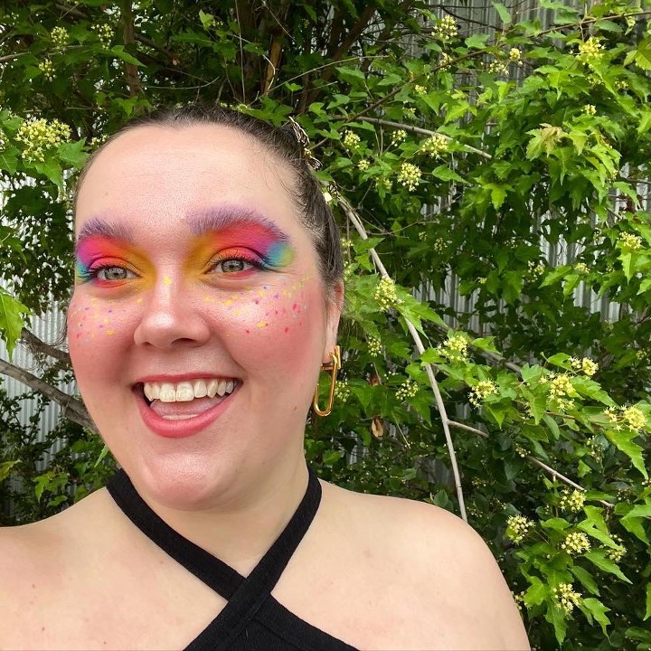Rhianne Fiolka smiles wearing colourful Pride makeup